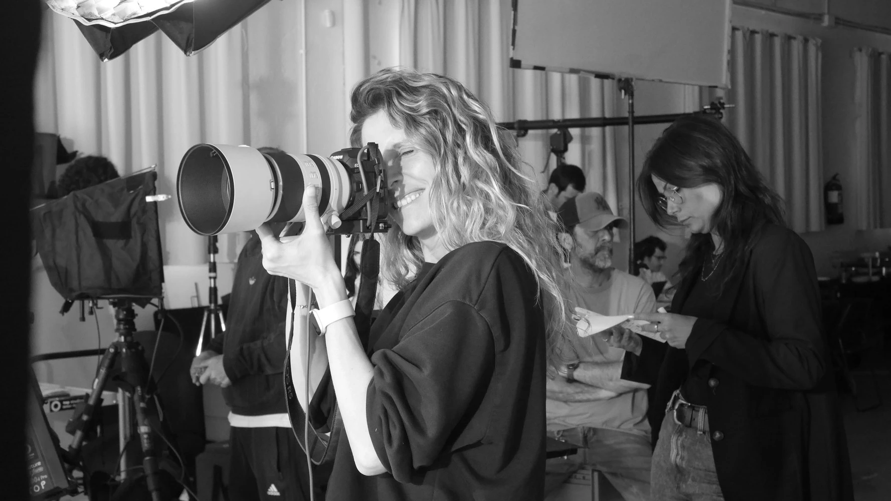 Black-and-white shot of a photographer with a long lens on a Tasty Studio set