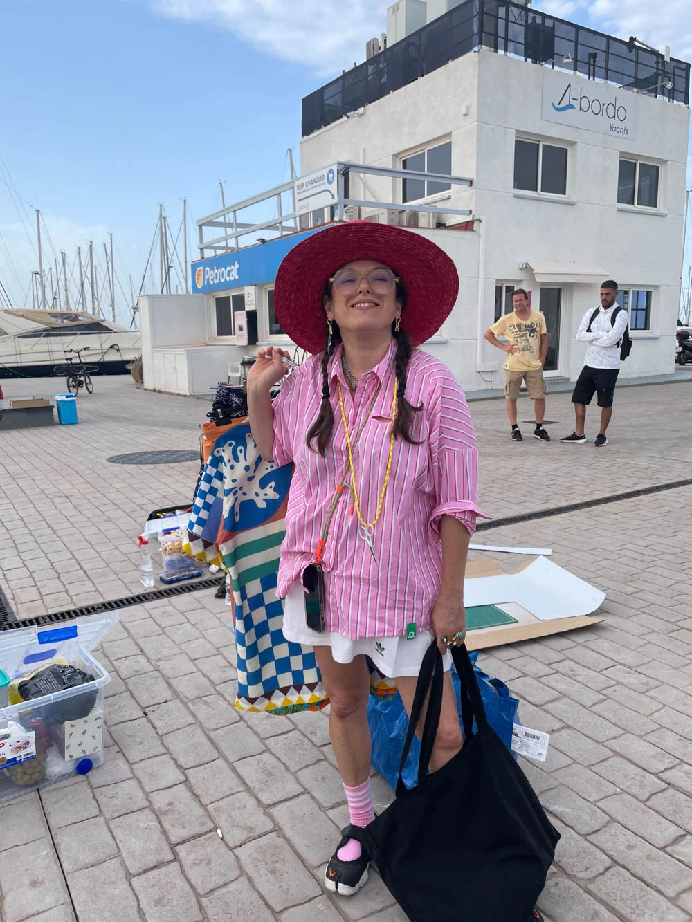 Woman in a wide red hat smiling at a marina location during a Glassy Films shoot