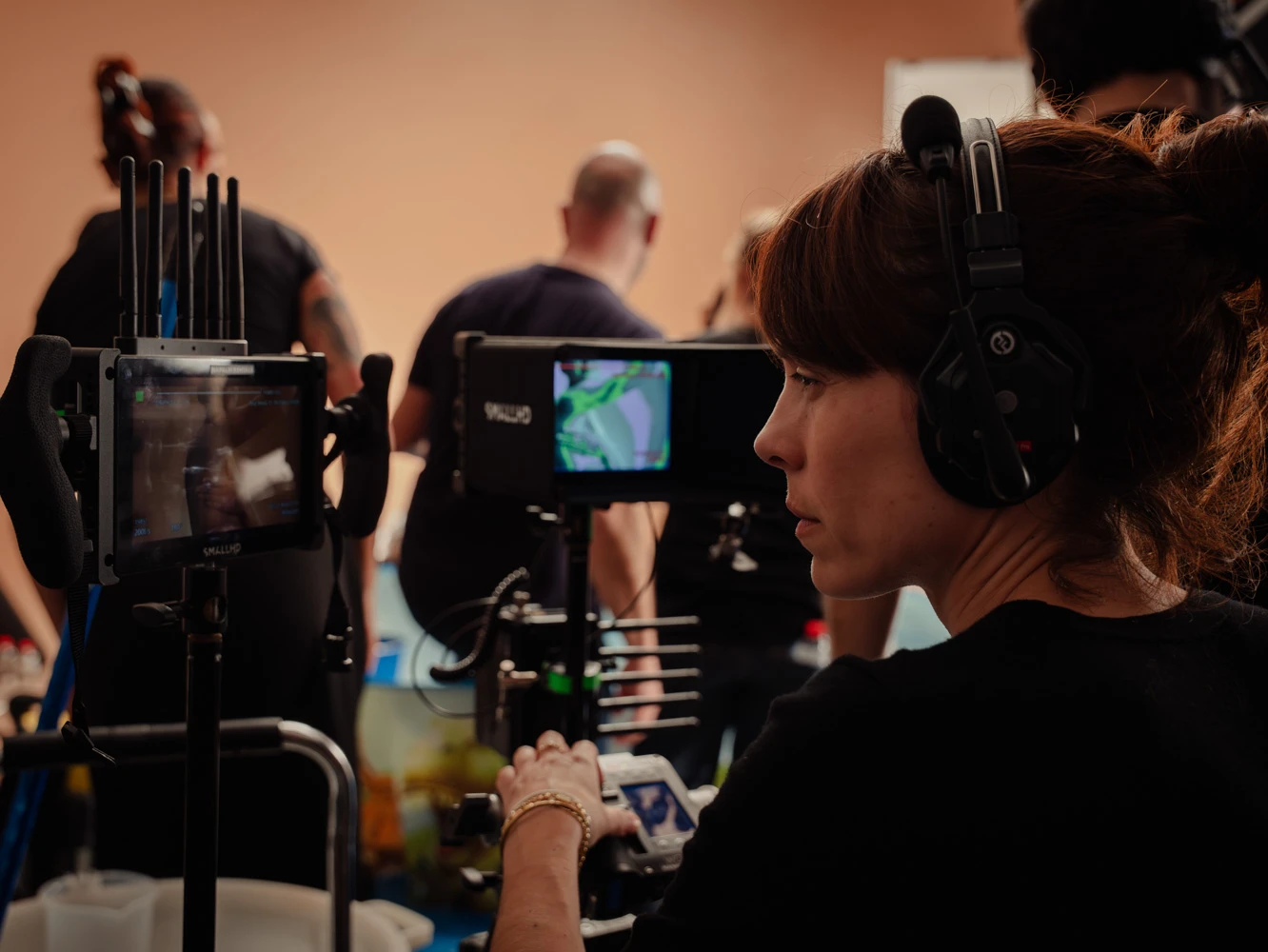 Crew member with headphones operating a remote camera head on a Tasty Studio set