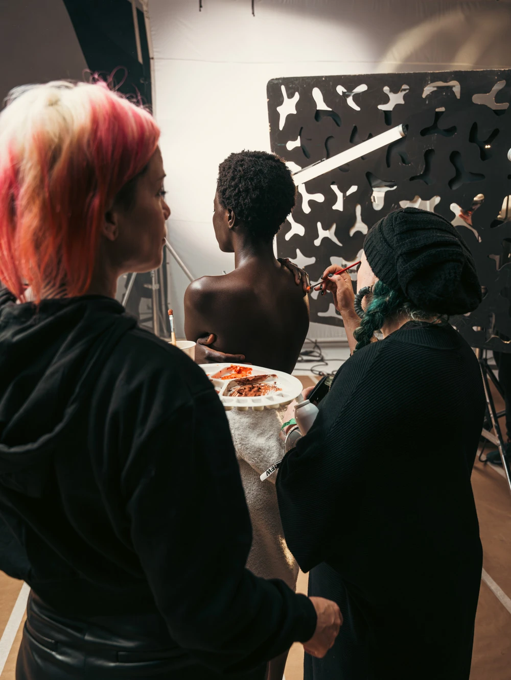 Make-up artists painting a model's skin on a Tasty Studio beauty set